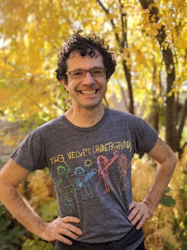 Ben Urwand smiling outdoors in front of fall foliage