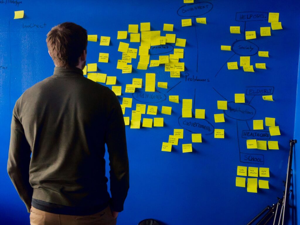Student brainstorming ideas with sticky notes during a college essay coaching session