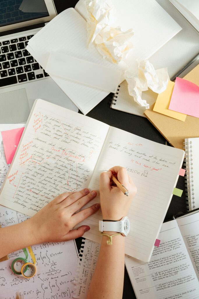Student editing a college essay draft by hand with feedback notes, as part of a college essay coaching session